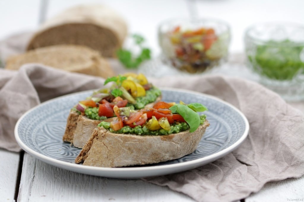 Bruschetta-Variante. Vollkorn-Baguette mit Kräuterpesto und Tomaten