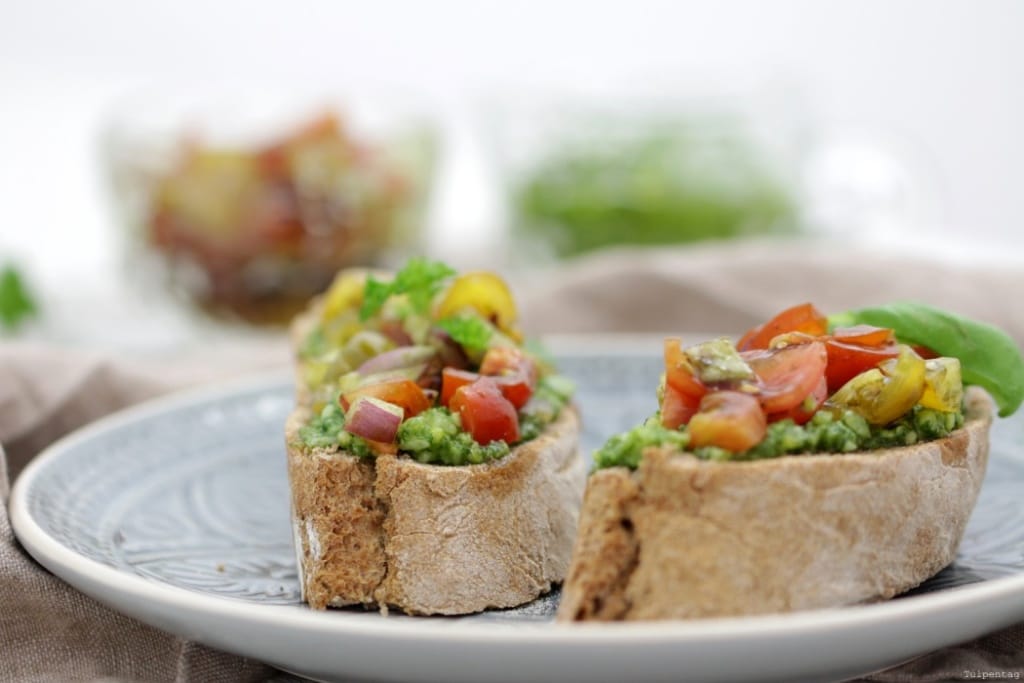 Bruschetta-Variante. Vollkorn-Baguette mit Kräuterpesto und Tomaten