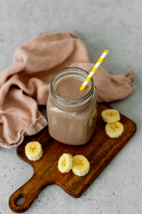 Smoothie zum Frühstück. Ein Rezept mit Joghurt, gefrorener Banane, Haferflocken, Leinsamen und Kakao.
