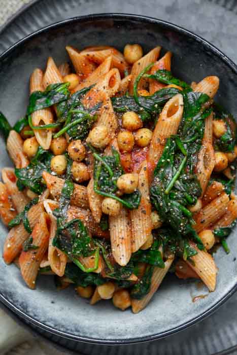 Pasta-Rezept. Nudeln mit Spinat, Kichererbsen, passierten Tomaten und Oregano. Schnell, lecker einfach, vegan, vegetarisch, ausgewogen.